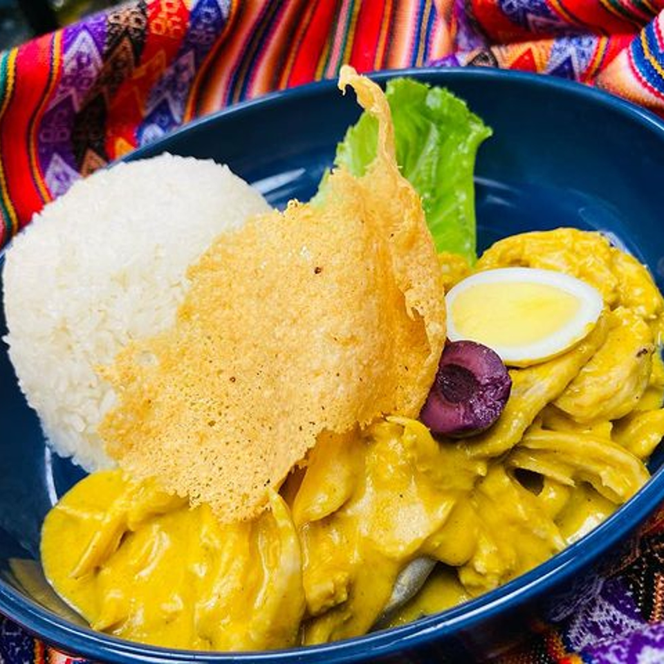 Nazca Grill's Aji de Gallina, a Peruvian dish with yellow creamy chicken, rice, egg, olive, and cheese crisp.